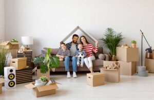 Homeowners organize a bright living room while cleaning windows and preparing the property for sale.