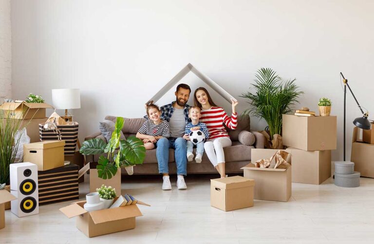 Homeowners organize a bright living room while cleaning windows and preparing the property for sale.